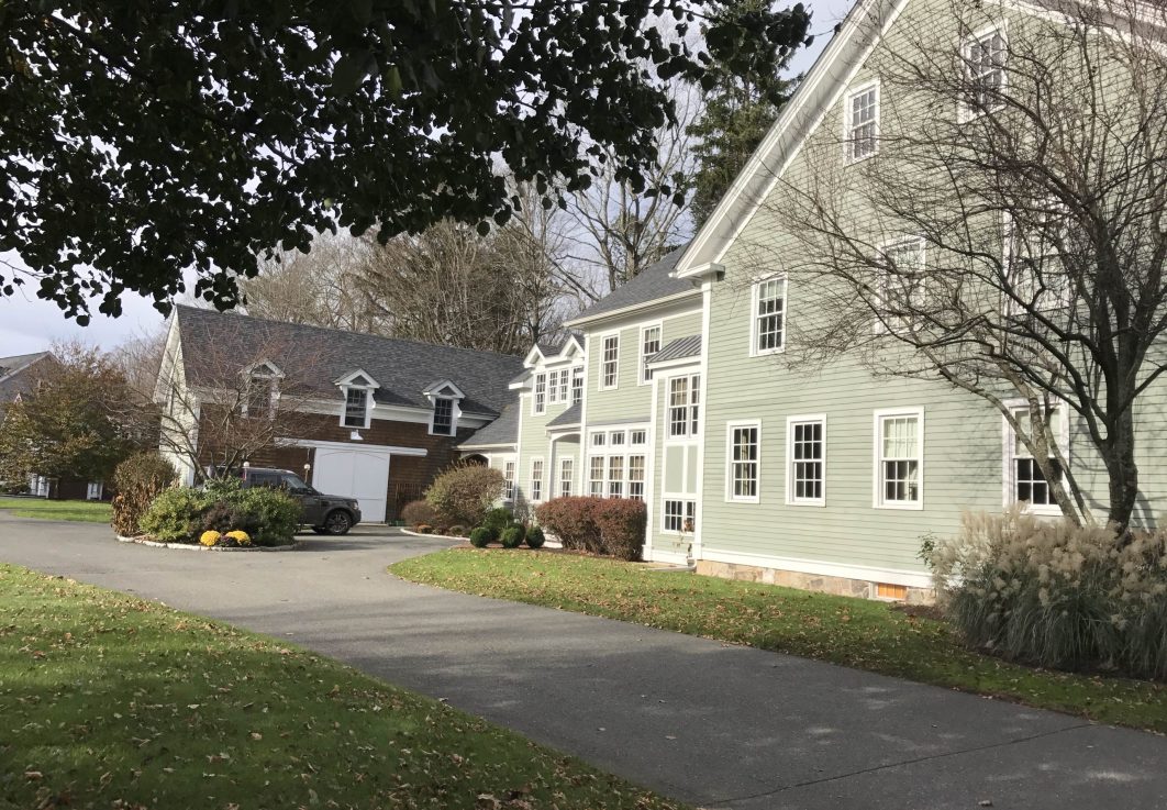 Picture of house with long driveway and car parked near barn